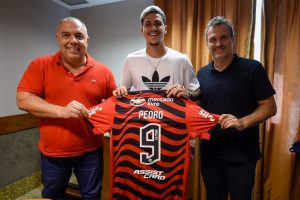 Pedro exibe camisa do Flamengo ao lado de Marcos Braz e Bruno Spindel, após renovação de contrato.